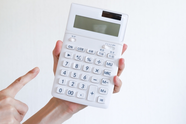 電卓を手に取り、収支計画の明瞭さを示すイメージ写真